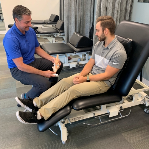A physiotherapist explaining how a knee works to a patient