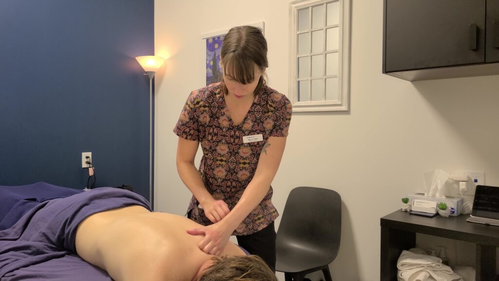 A Massage therapist working on man's shoulder